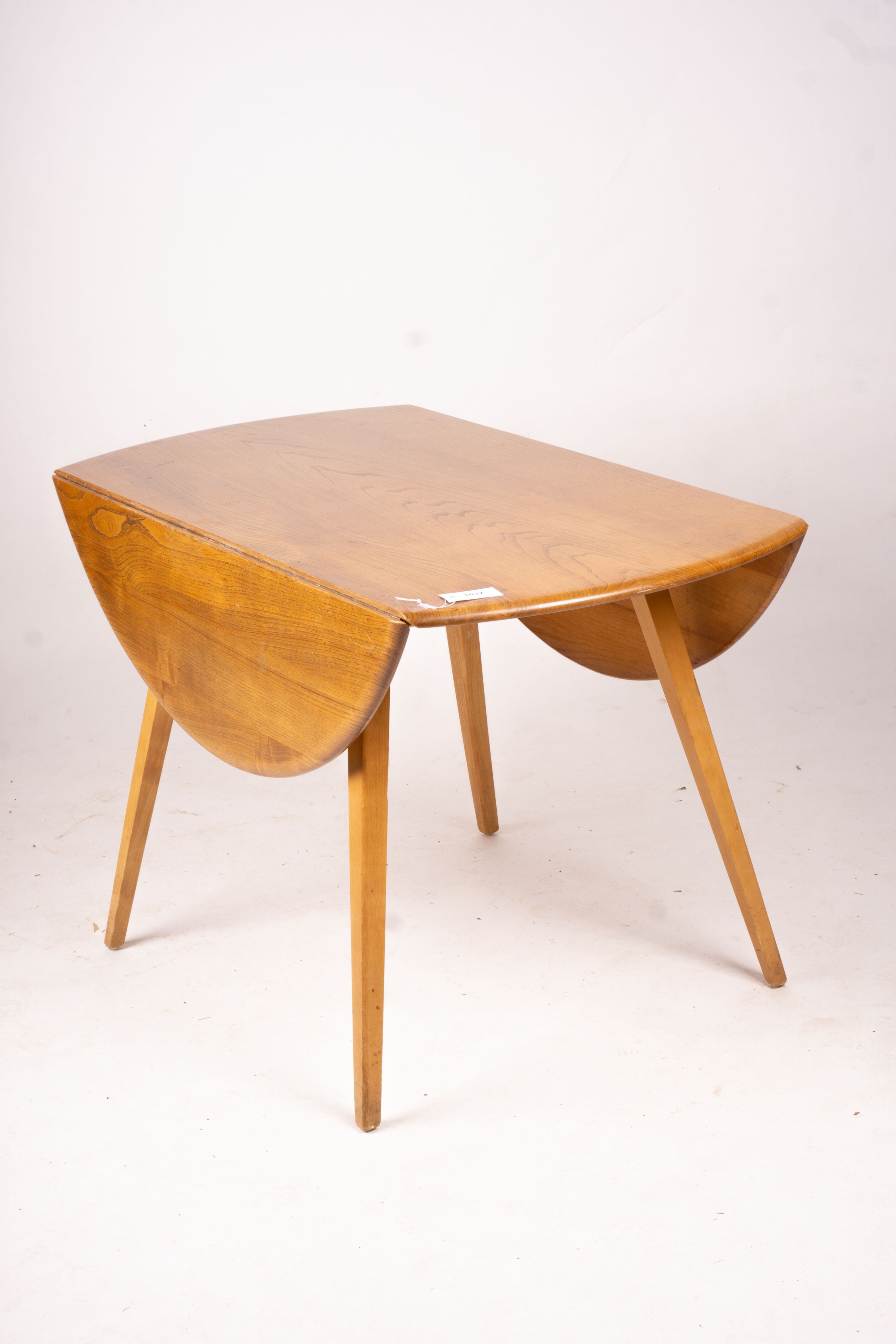 An Ercol light elm and beech circular drop leaf dining table, length 124cm extended, width 113cm, height 72cm